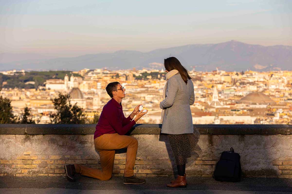 Surprise wedding marriage proposal condifly photographed at a distance by the Andrea Matone photographer studio in Rome Italy. Proposal in Janiculum hill