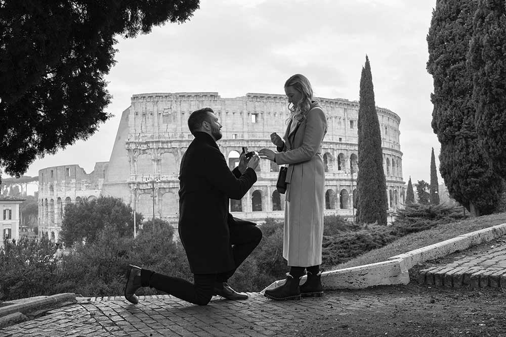 Proposing matrimony on the side of a park in Rome with a view of the Roman Colosseum in the far distance. Image professionally converted in black and white