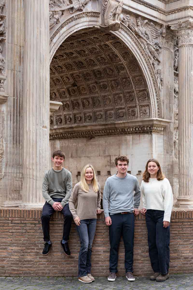 Taking family pictures in Rome standing underneath an ancient arch in Rome at the Forum 