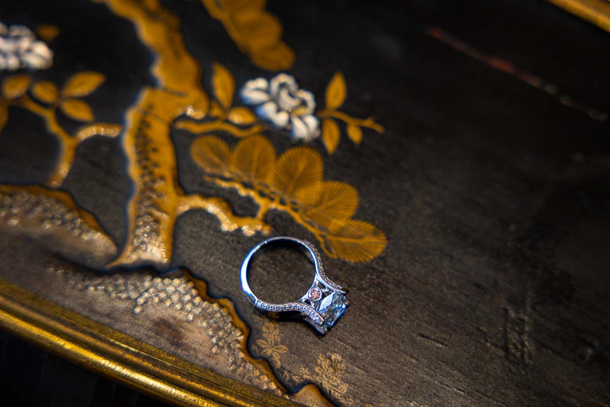 Anniversary ring close up photo taken from above while resting on an antique Italian table top 