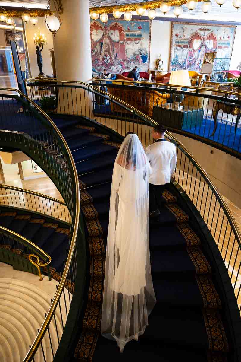 Groom escorting the bride up the stairs leading to the hotel hall to begin their photography session in Rome Italy