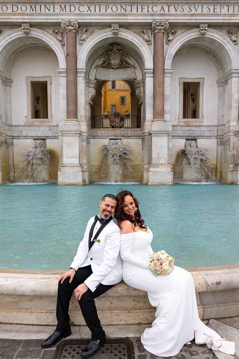 Couple portrait picture taken during a wedding photoshoot in Rome Italy. Standing on the edge of the Fontanone water fountain on the Janiculum hill