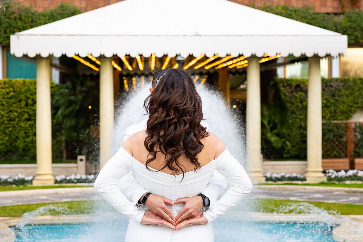 Newlyweds making a heart shaped hands gesture at the end of their Rome photo shoot in Italy