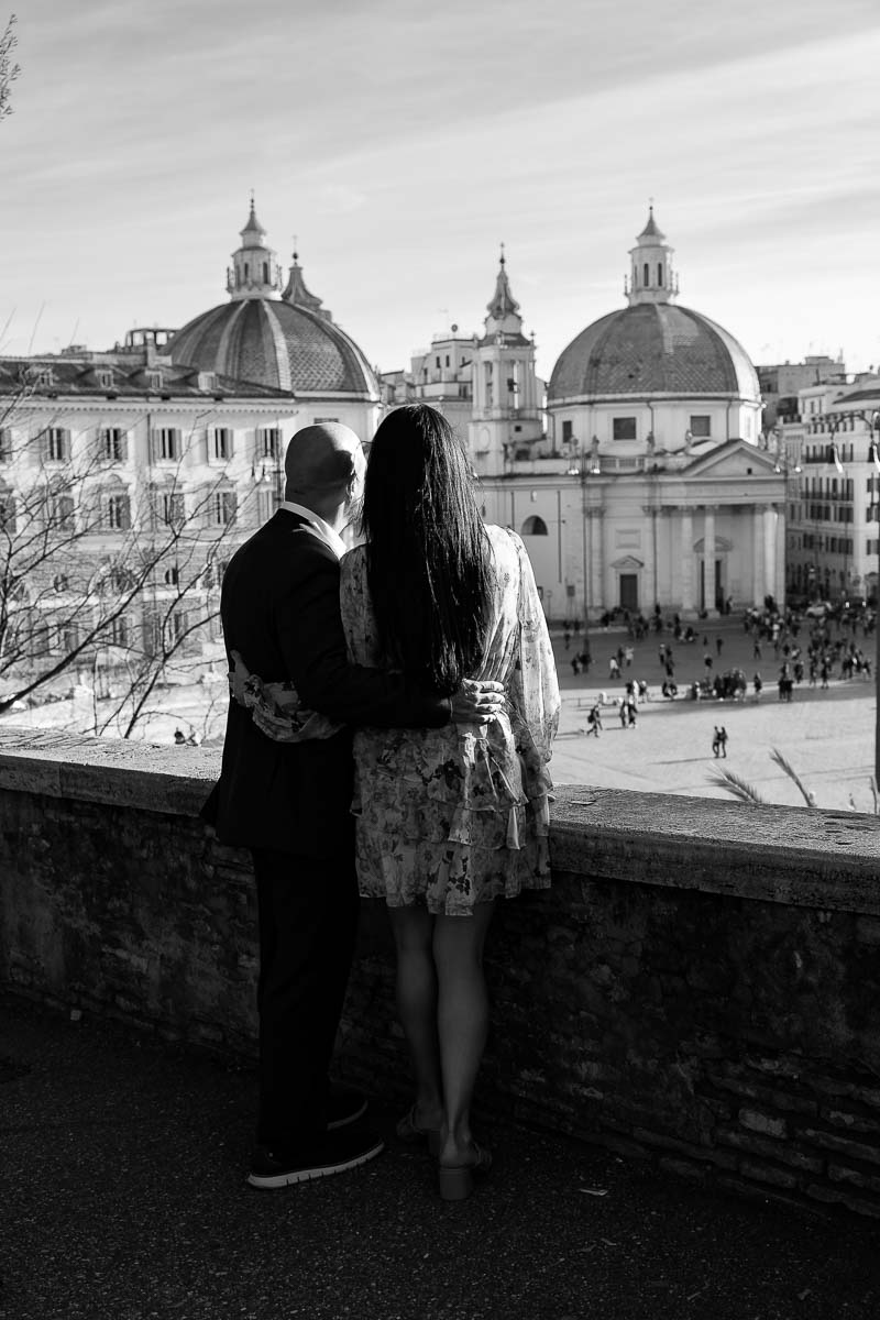 Couple admiring the view of the twin churches in Piazza del Popolo in b&w 