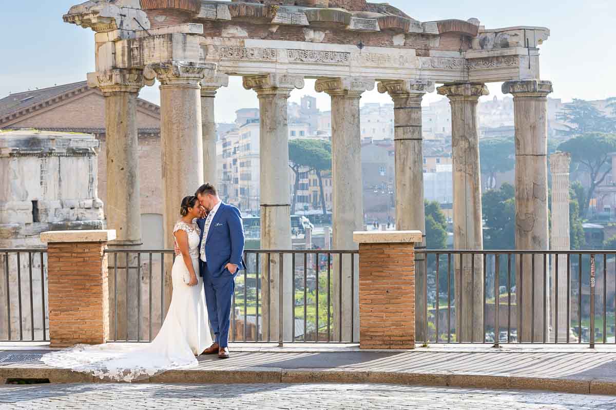 Newlywed couple standing and posing by the ancient roman forum 