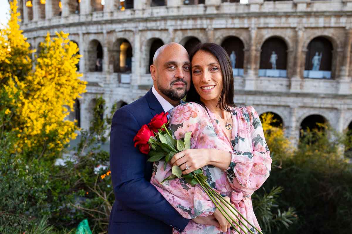 Couple pose portrait in Rome with a bouquet of red roses