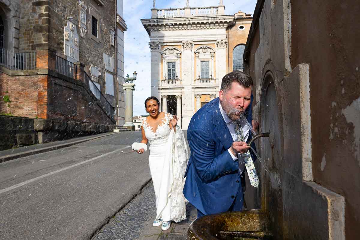 Drinking from a water fountain during a fun and creative Elopement Wedding Photoshoot in Rome Italy 