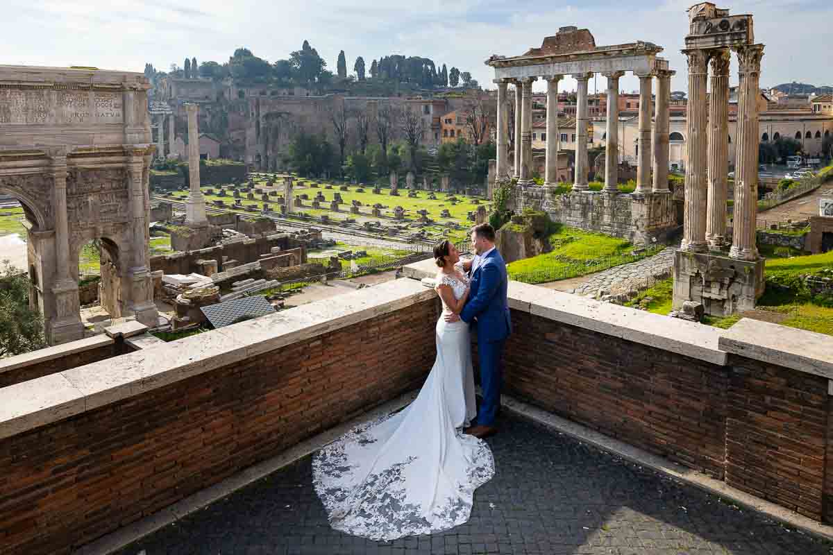 Wedding couple posing by the forum with the view of the whole ancient city in the background 