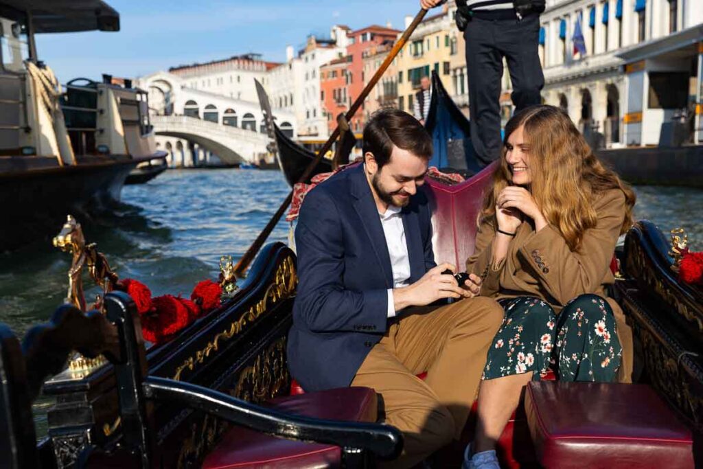 Venetian gondola proposal photographed by a photographer on Canal Grande with the Rialto bridge in backdrop