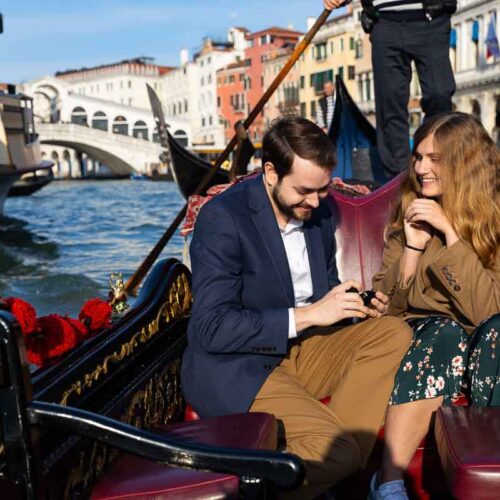 Venetian gondola proposal photographed by a photographer on Canal Grande with the Rialto bridge in backdrop