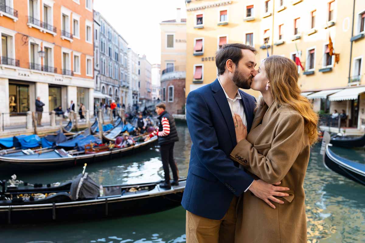 Couple kissing in front of Venetian gondolas