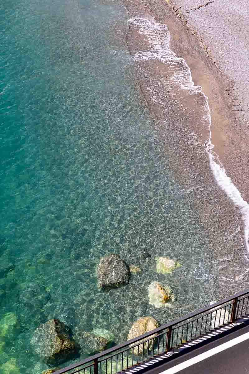 The beach and water surface framed by the road side 