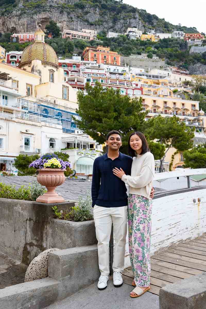 Couple portrait in front of the vertical town among beautiful blossoming flowers 
