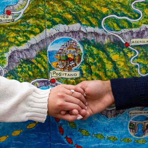 Engagement ring photography taken in front of a ceramic map of the town of Positano Italy