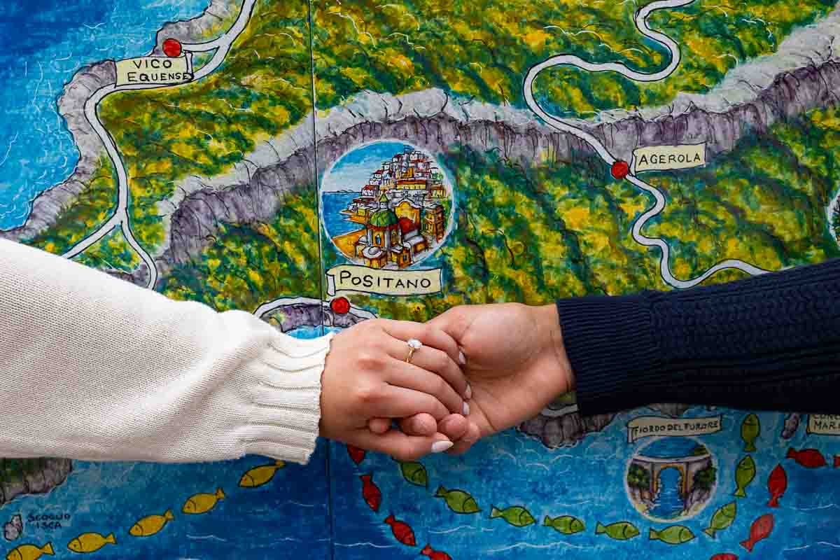 Engagement ring photos taken in front of a ceramic map of the town of Positano Italy right after a romantic proposal 