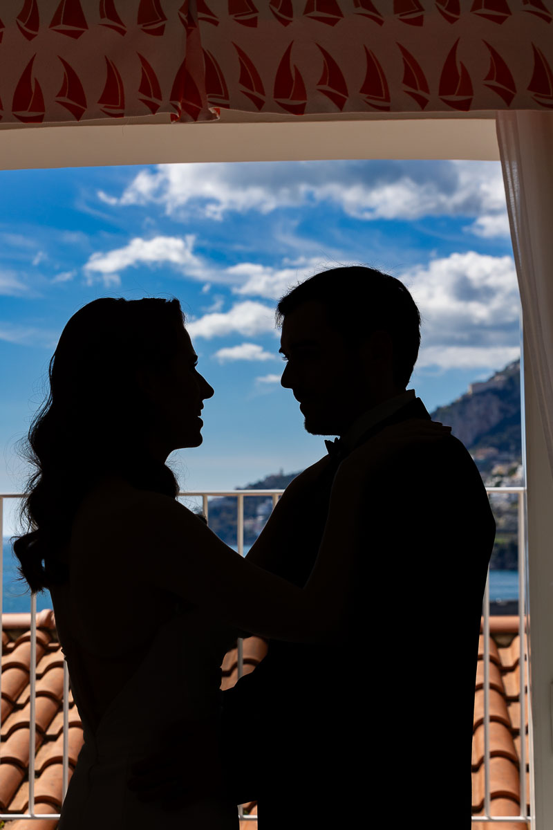 Couple in silhouette taking pictures together during a preliminary photoshoot in the hotel room