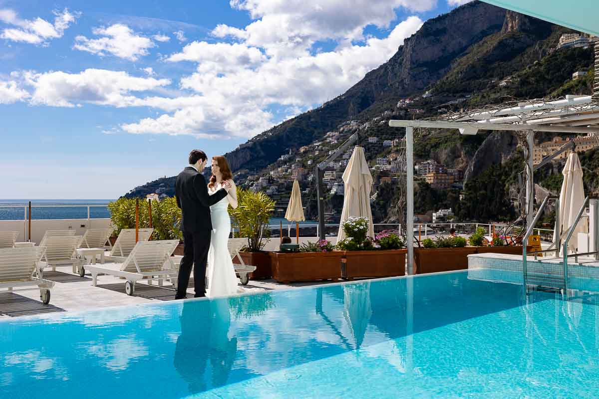 Taking elopement pictures of the newlywed couple with the town of Amalfi in the background together with the whole coast view