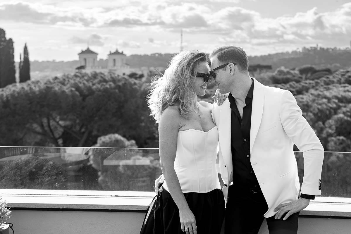 Black & White photography of a couple posing together before the roman skyline