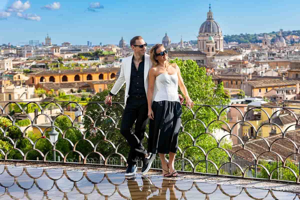 Couple photography session on the Pincio terrace in Rome on a sunny day after rain that created water puddles