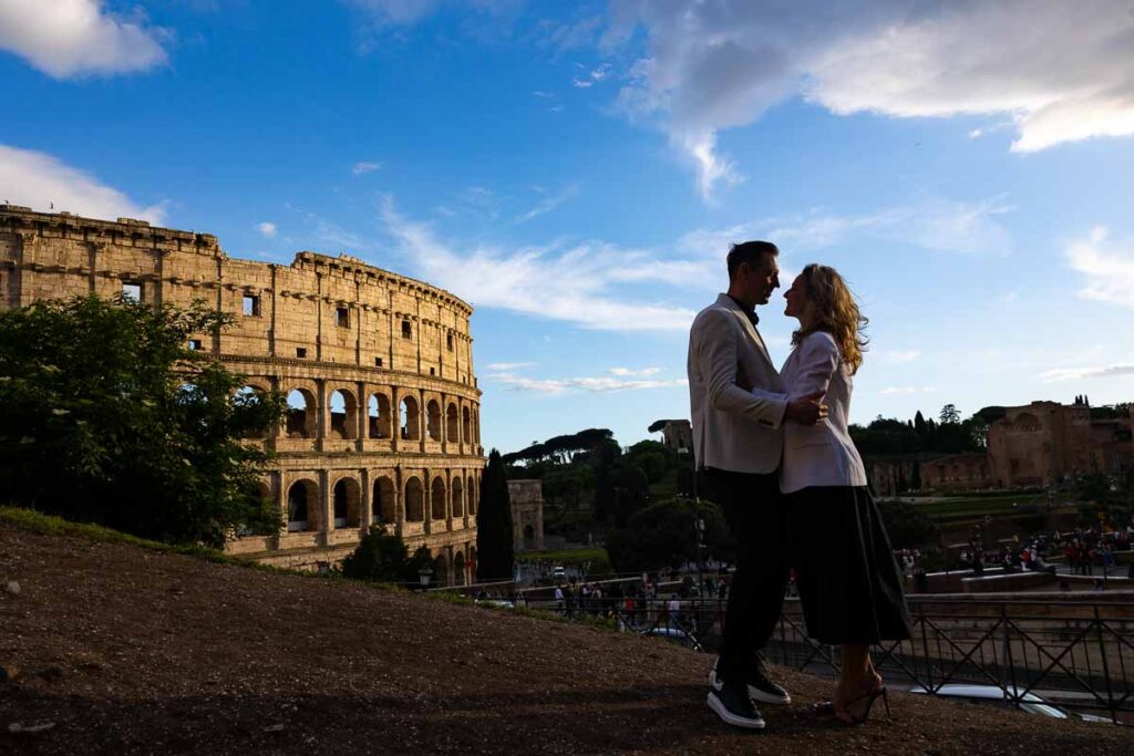 Photo shooting at the Roman Colosseum as silhouettes emerge from the sun setting with bright vivid colors