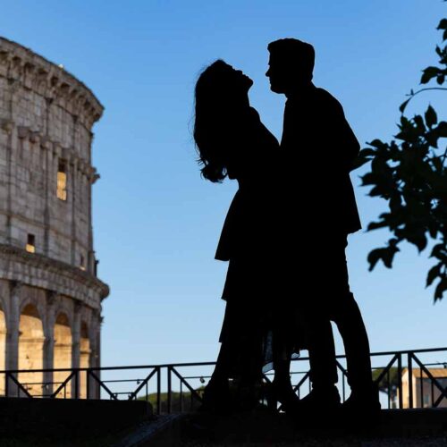 Silhouette photo of a couple photographed against blue sky at the Roman Colosseum during a photographer session in Rome Italy