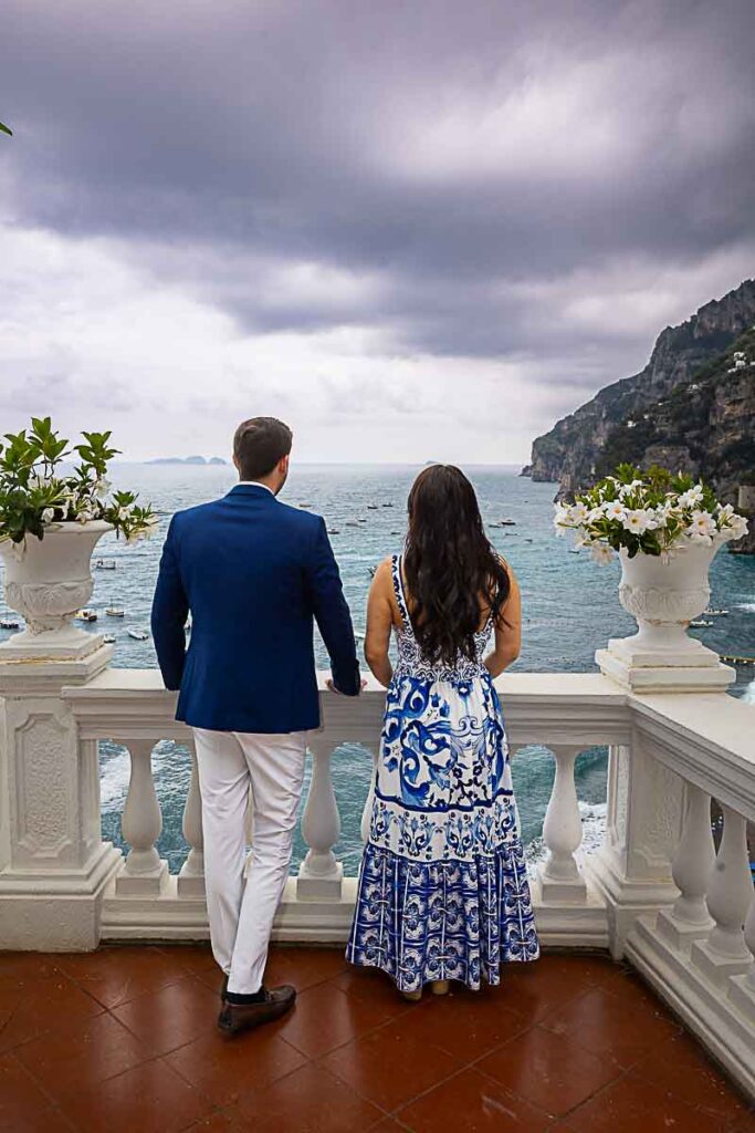 Couple admiring the mediterranean sea from a hotel balcony during a photography session on the Amalfi coast