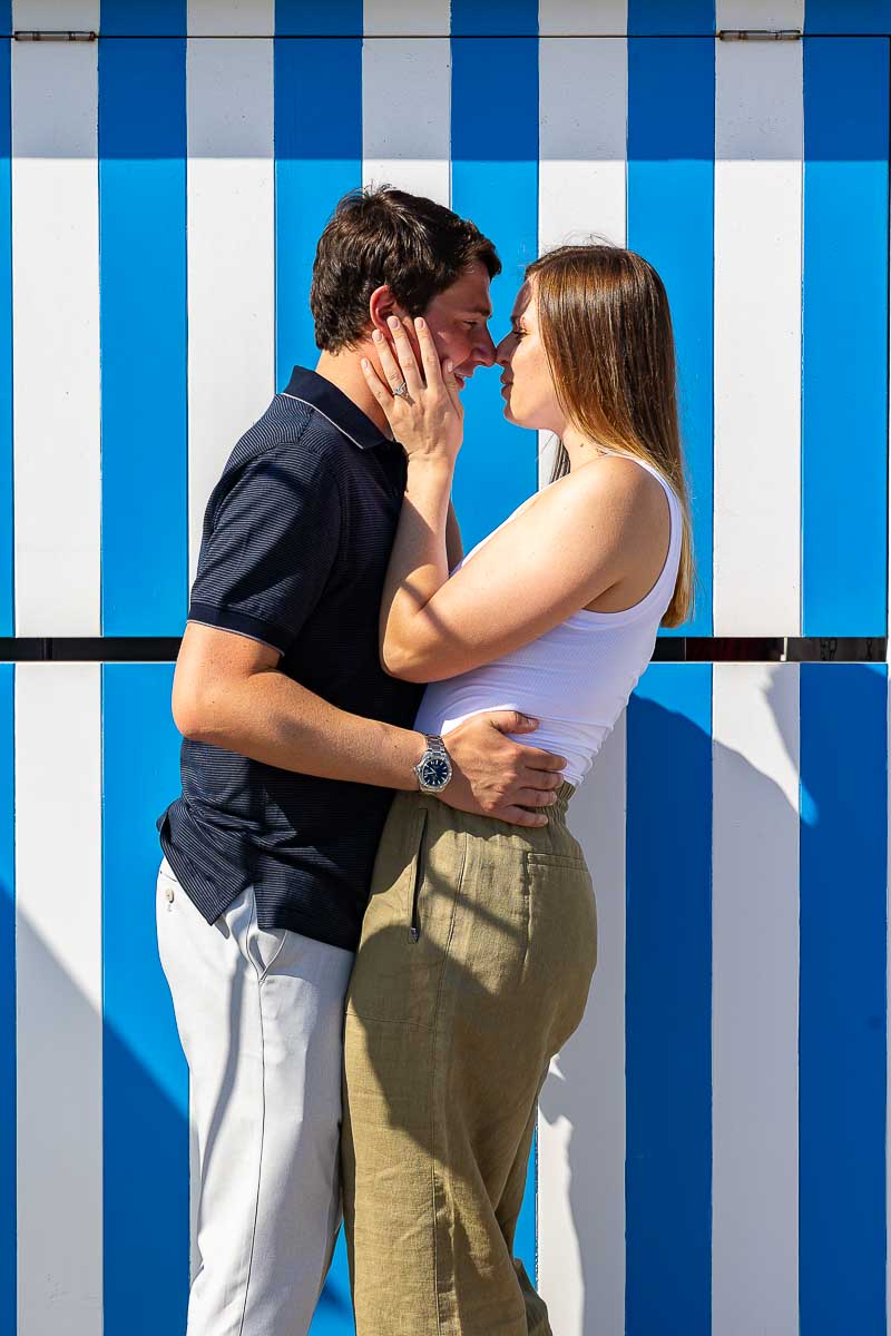 Couple sideway portrait taken in front of vertical blue and white lines summer lifestyle photography 