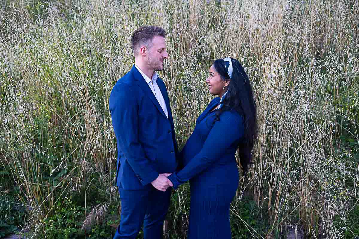 Standing in front of one another in a field with tall grass 
