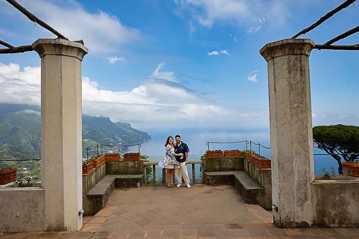 Far away shot showing the couple standing before the magnificent view of the coastal views photographed during a lifestyle photography session 