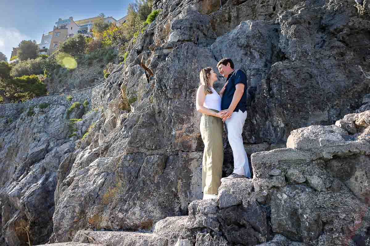 Engaged photos taken on the rock steps of a seaside cliff hill 