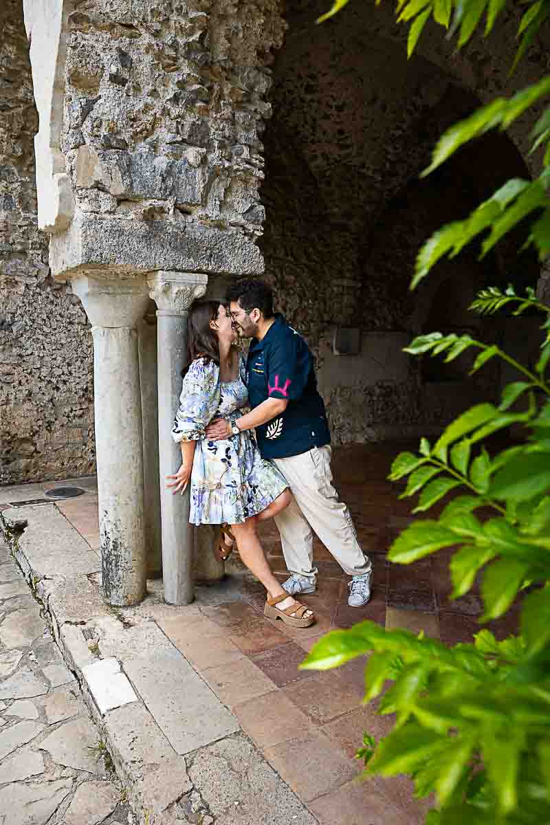 Couple posed by a marble column while taking pictures together 