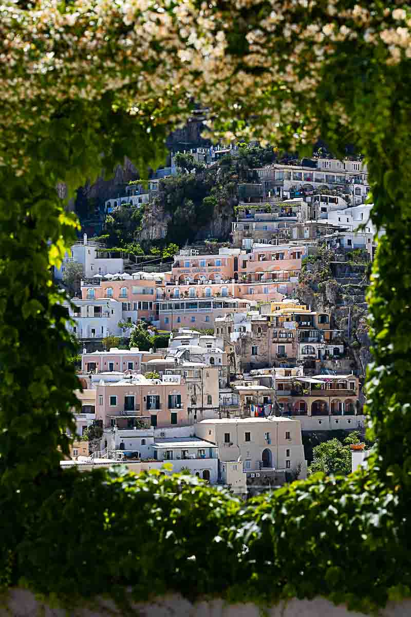 Scenic view of Positano with white jasmine vines in the foreground during a romantic engagement photo session