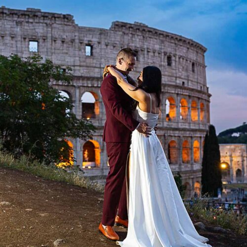 Couple taking pictures at night during a wedding photoshoot at the Colosseum in Rome Italy