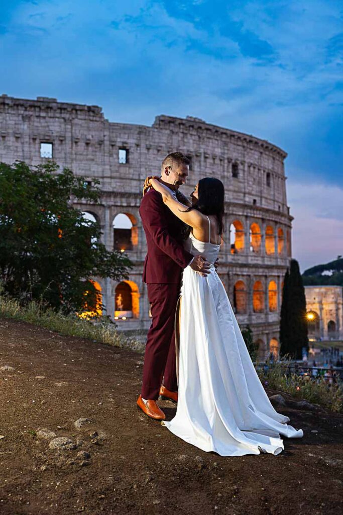 Couple taking pictures at night during a wedding photoshoot at the Colosseum in Rome Italy