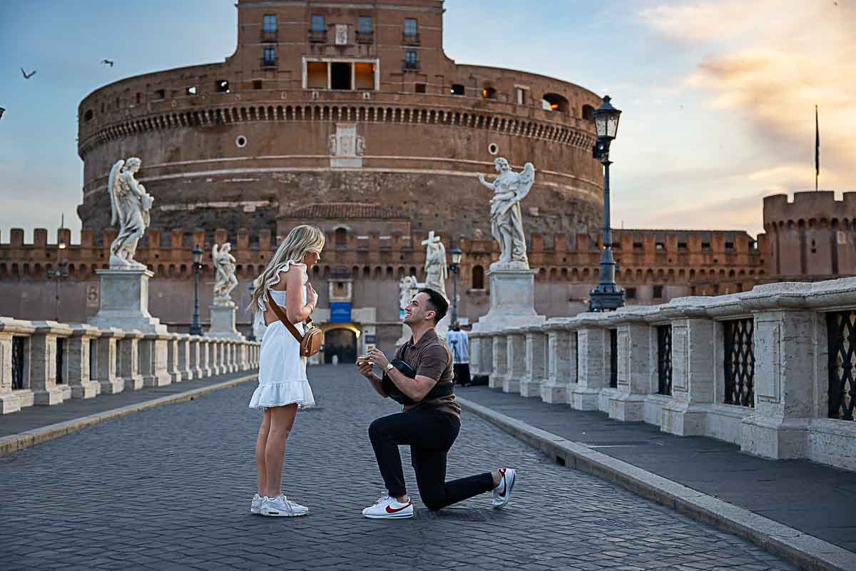 Knee down wedding marriage proposal asked in the early morning on the Castel Sant Angelo bridge in Rome Italy 