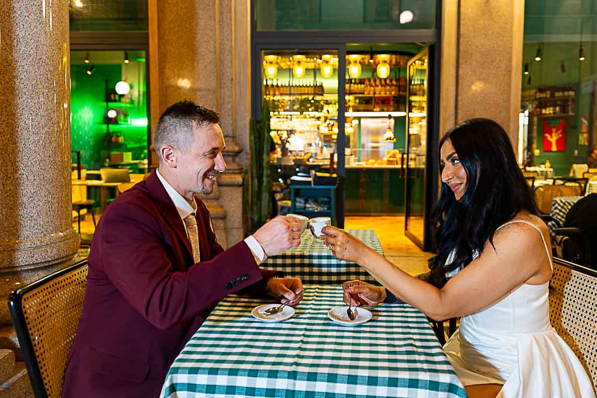 Just married drinking espresso coffee together while sitting at a table in a café 