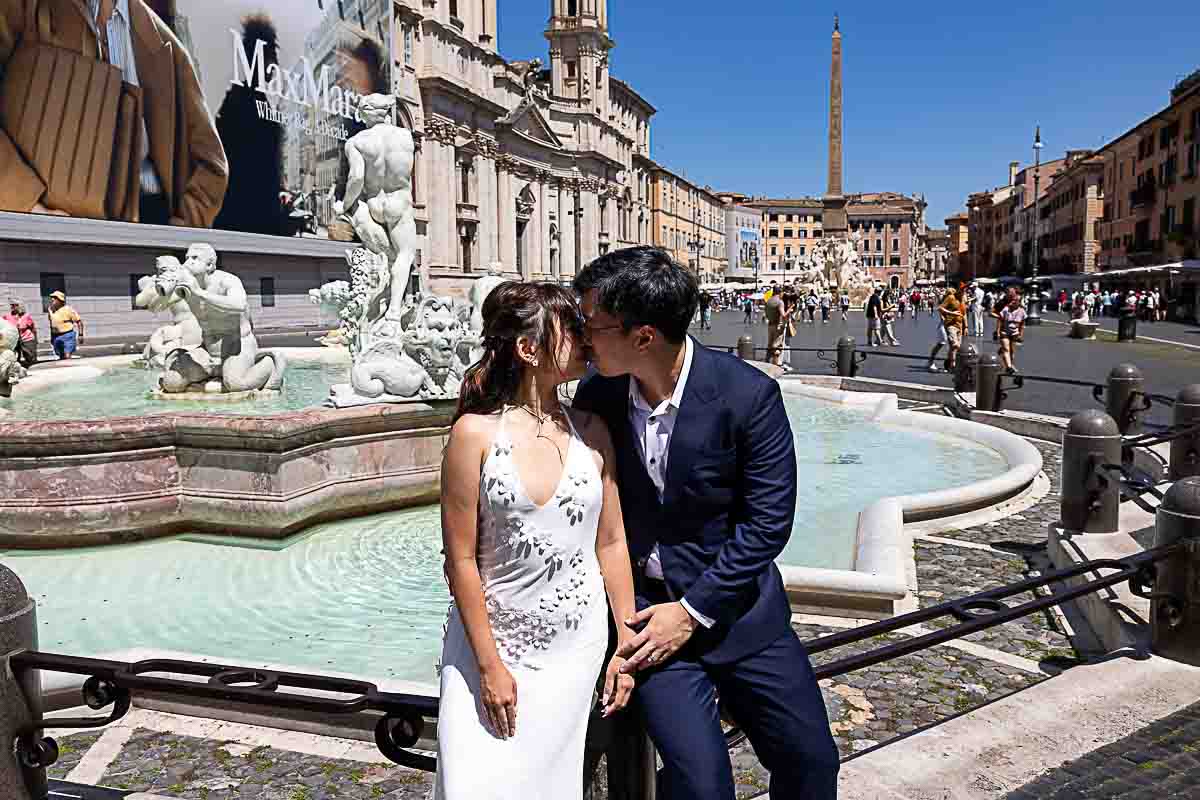 Kissing by the Piazza Navona water fountain in Rome Italy during a pre wedding photo session in Rome Italy 