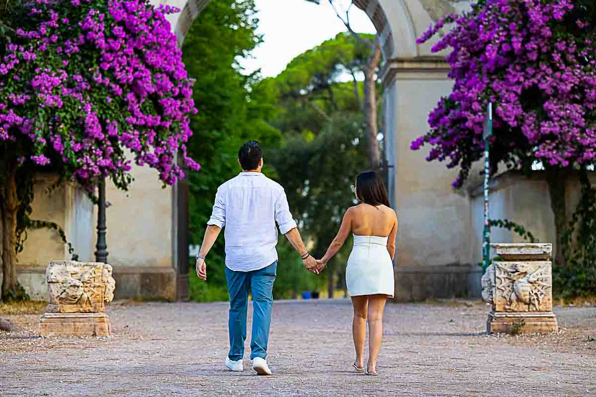 Walking hand in hand towards the park entrance while strolling during a photoshoot in Rome 