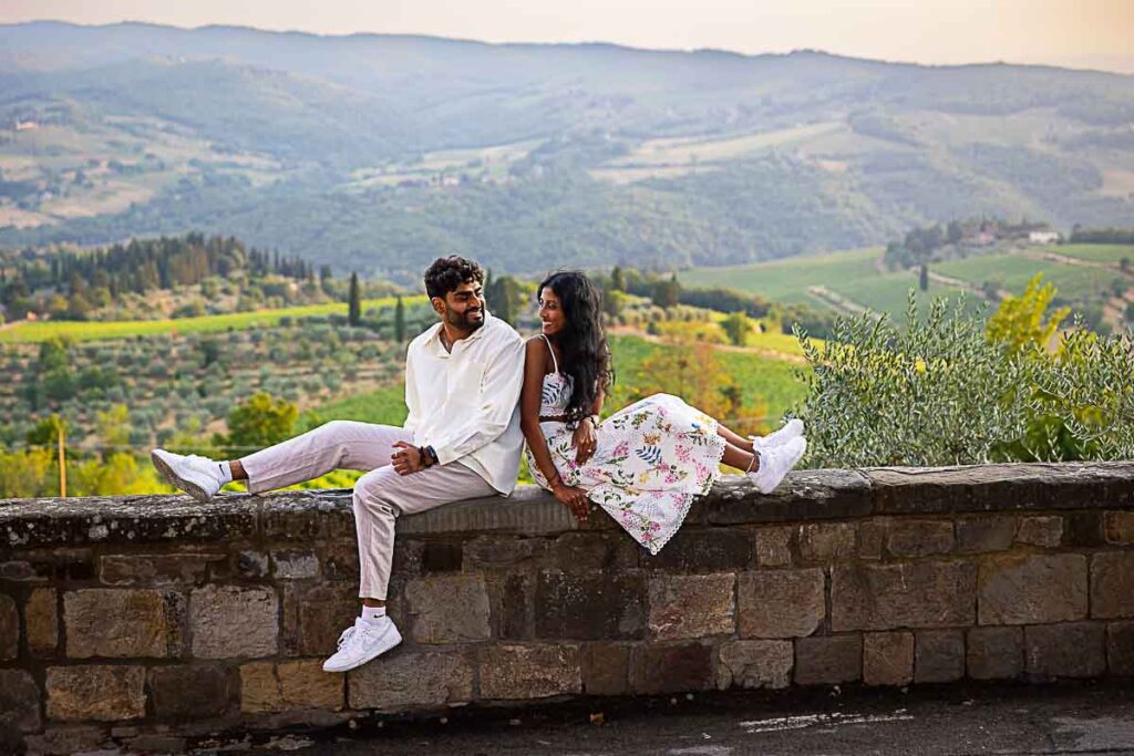 Sitting down on a ledge taking engagement photos during a proposal photoshoot in Tuscany Italy