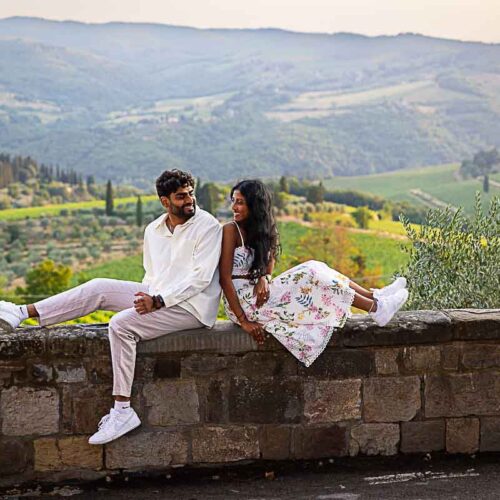 Sitting down on a ledge taking engagement photos during a proposal photoshoot in Tuscany Italy