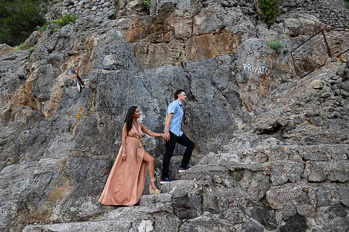 Walking on a cliff while holding hands and being together during a photography session