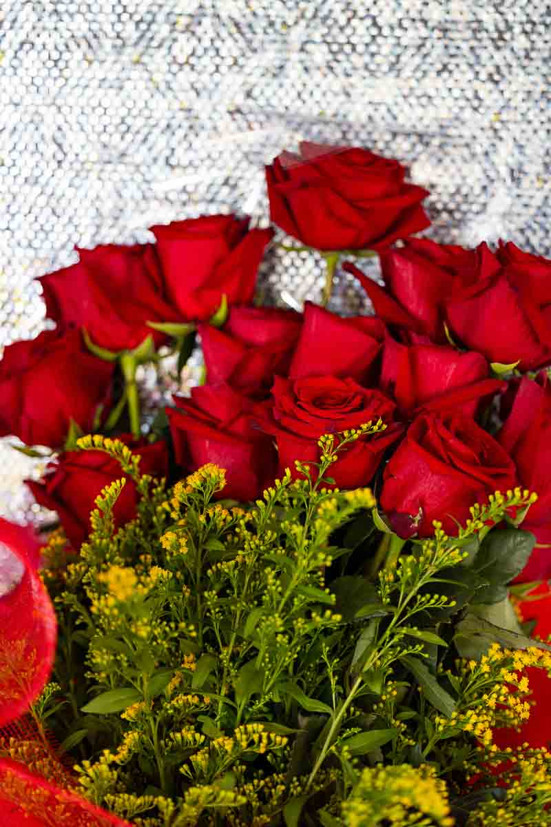 Close-up of engagement ring on bouquet of red roses on terrace in Rome