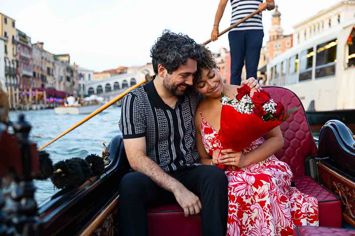 Engagement photo session with a bouquet of red roses given to celebrate engagement proposal 