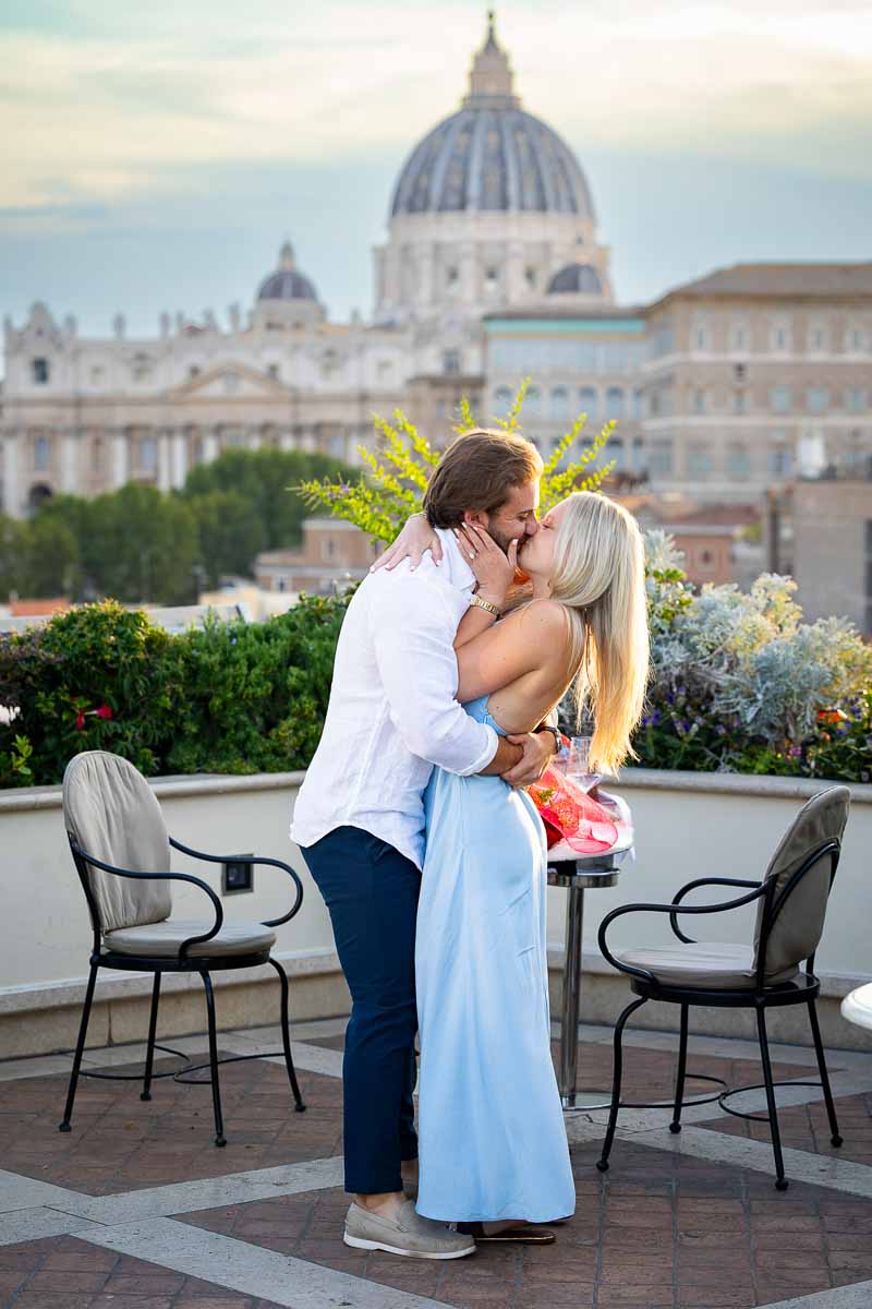 Candid moment of couple at terrace after proposal kissing 