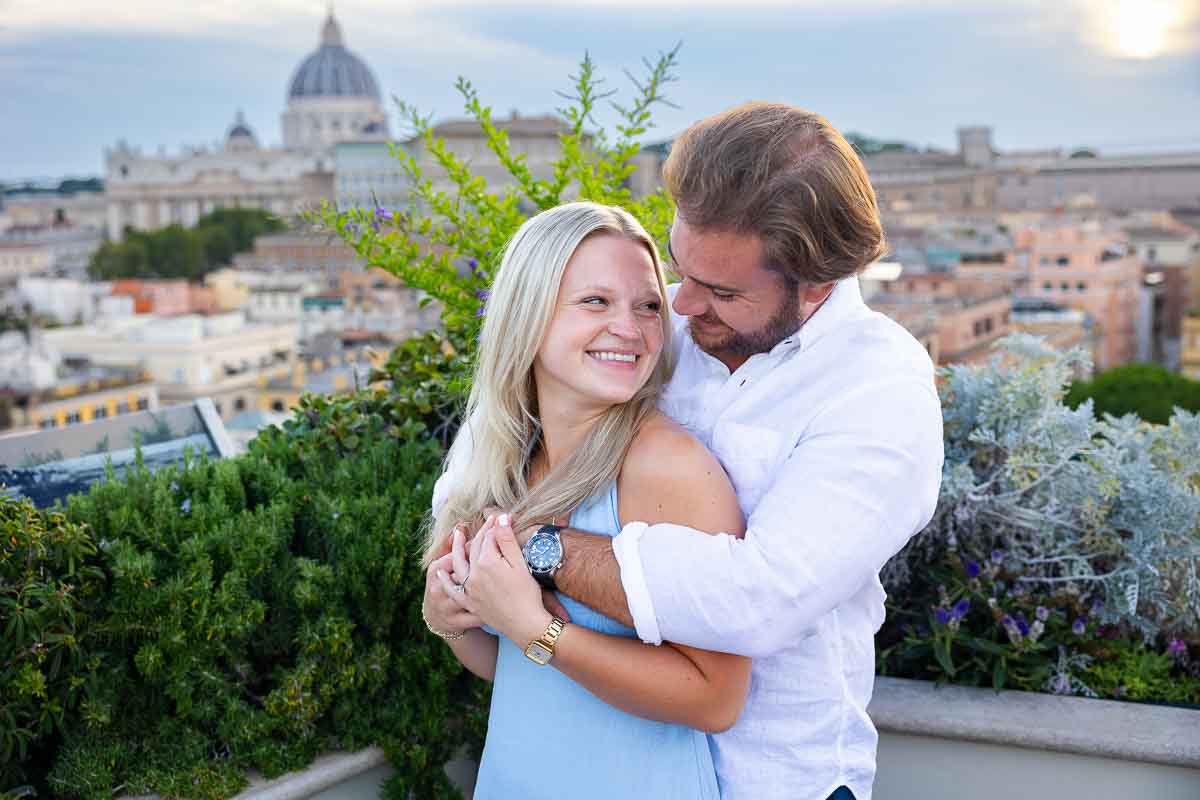 Embrace photo pose for the engagement pictures with Saint Peter's dome in the far distance backdrop 