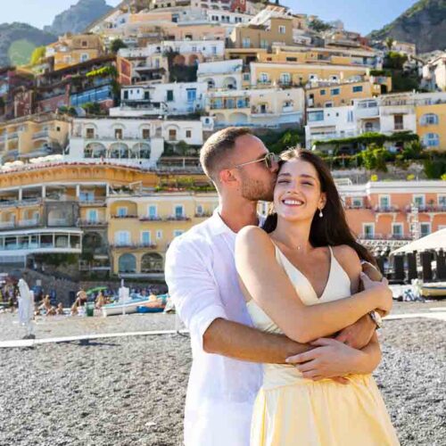 Portrait picture of a just engaged couple holding each other before the town in the back