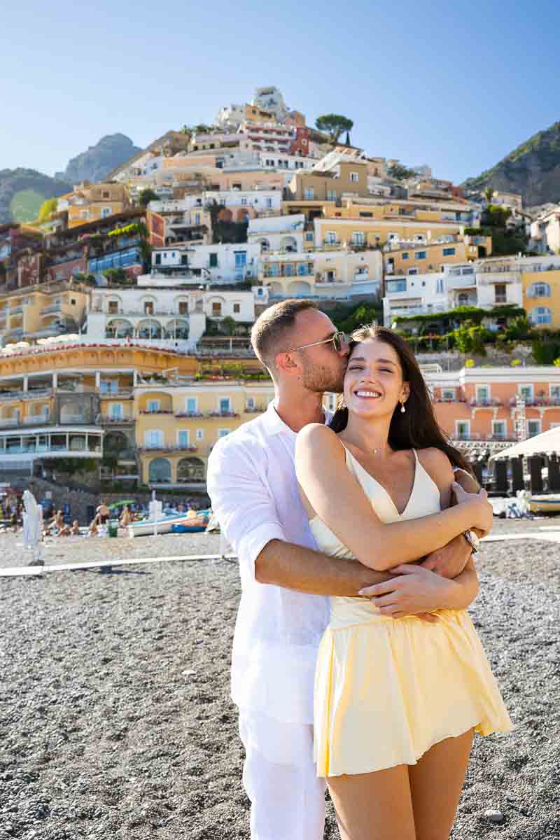 Portrait picture of a just engaged couple holding each other before the town in the back 