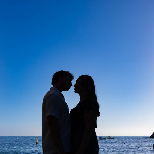 Silhouette artistic photography of a couple next to one another in ina image with blue sky