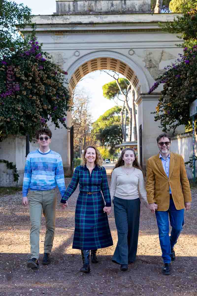 Walking hand in hand as to enter the park together passing through the arch that is found at the entry 