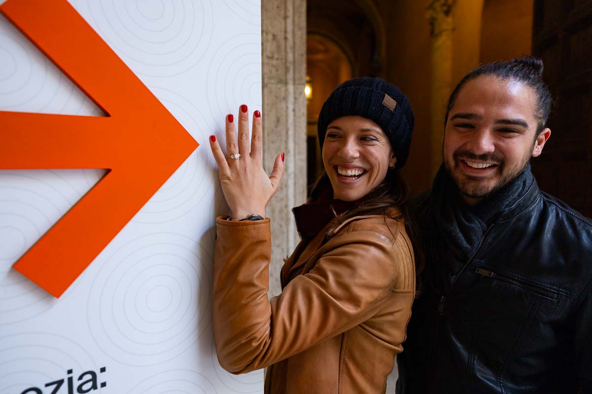 Arrow indicating the diamond ring while on a fun and creative engagement photo session in Italy